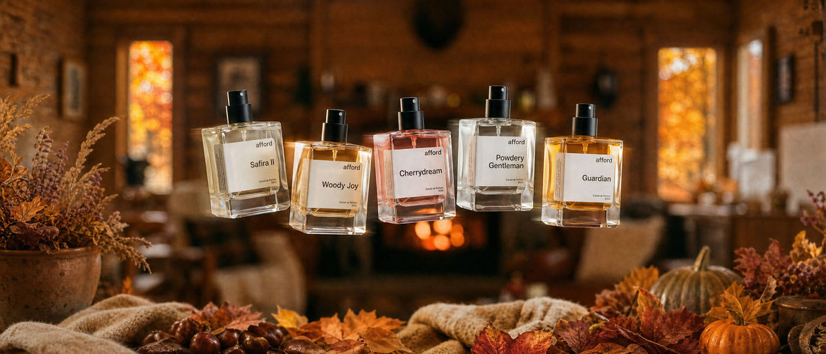 Afford-Parfums schweben in einer herbstlichen Hütte vor dem Kamin, davor Herbstlaub, Kastanien und Kürbisse